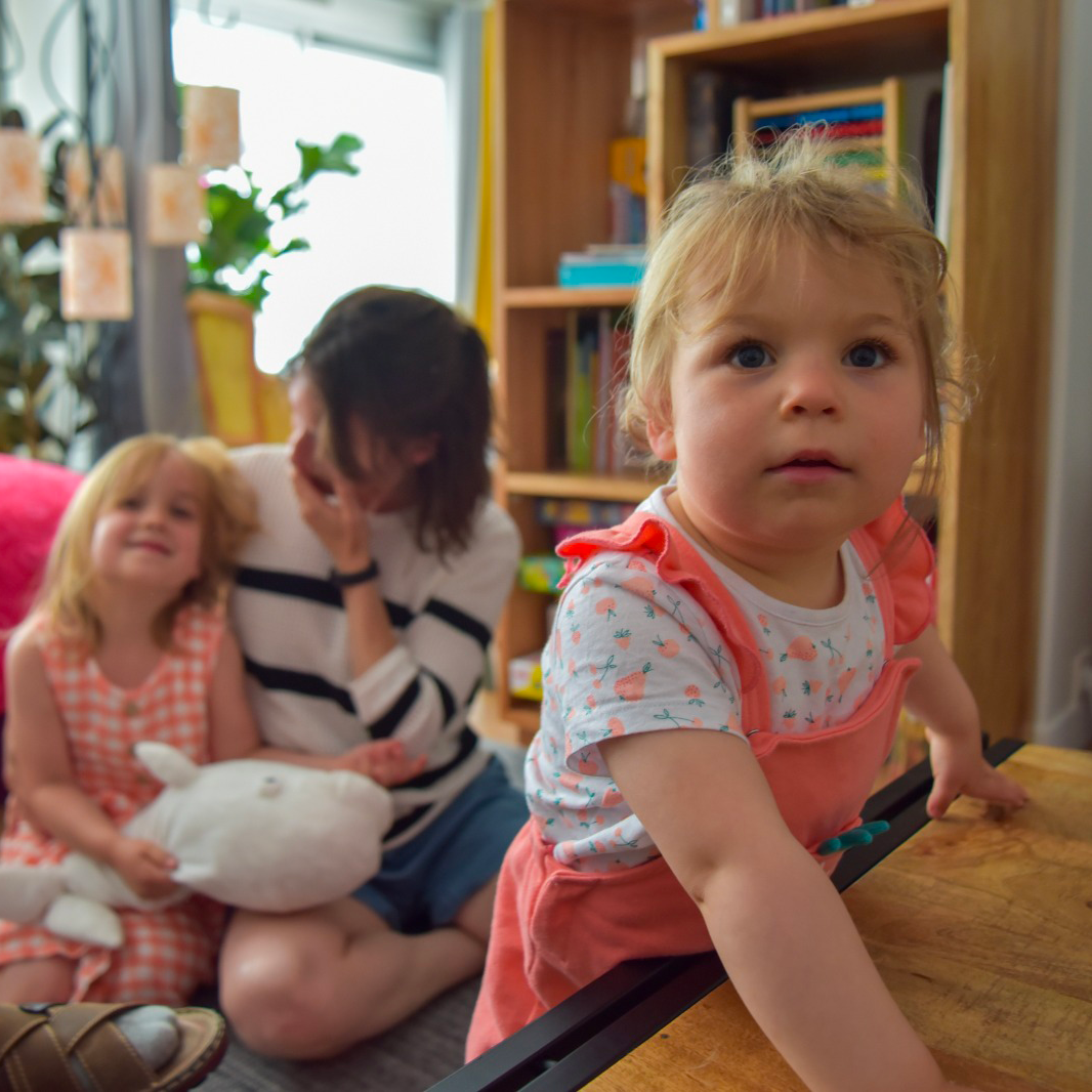 Parents jouant avec leur enfant en situation de handicap dans leur salon, illustrant le répit et l’accompagnement des familles au quotidien.